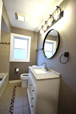 a bathroom with a toilet sink and mirror