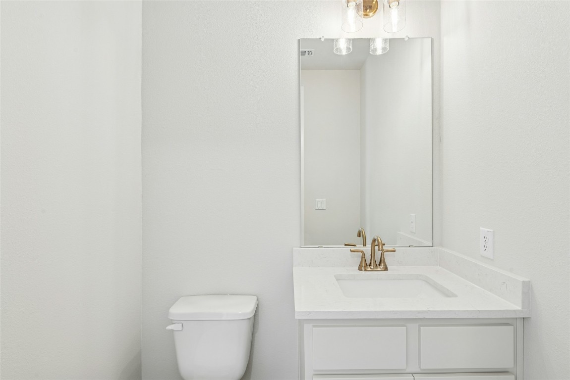 1528 Rodeo Ridge Drive Georgetown, TX 78628 - Photo 13 of 28 Half bath with vanity and toilet