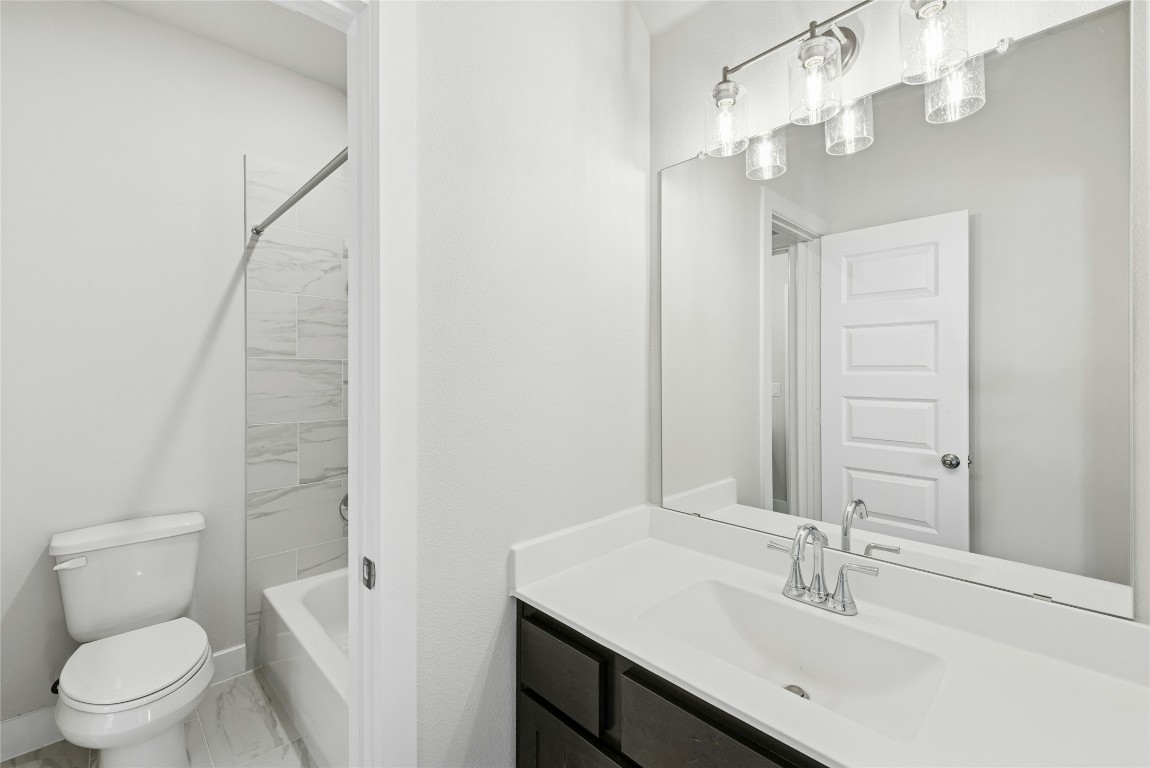 1528 Rodeo Ridge Drive Georgetown, TX 78628 - Photo 18 of 28 Bathroom featuring vanity, washtub / shower combination, and marble look tiles