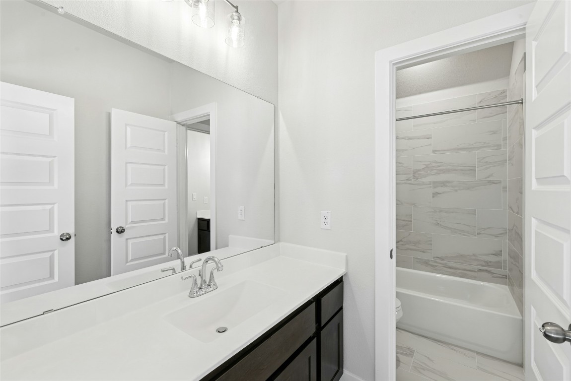 1528 Rodeo Ridge Drive Georgetown, TX 78628 - Photo 20 of 28 Bathroom featuring vanity, shower / tub combination, and light marble finish floors