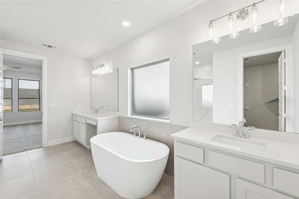 1528 Rodeo Ridge Drive Georgetown, TX 78628 - Photo 8 of 28 Bathroom featuring a soaking tub, two vanities, light tile patterned flooring, recessed lighting, and ceiling fan