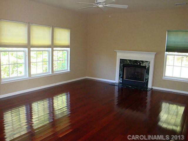 3741 Marbury Road Charlotte, NC 28269 - Photo 3 of 16 wooden floor fireplace and windows in an empty room