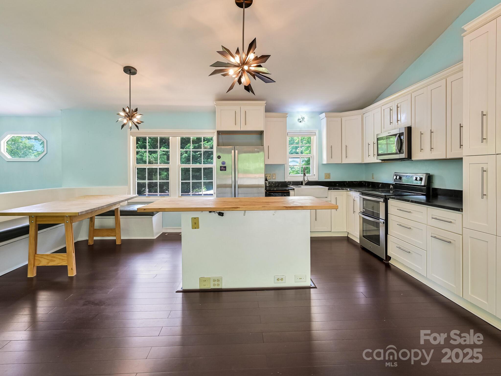 14 Spring Lake Drive Fletcher, NC 28732 - Photo 8 of 29 a kitchen with stainless steel appliances granite countertop a stove top oven a sink a dining table and chairs with wooden floor