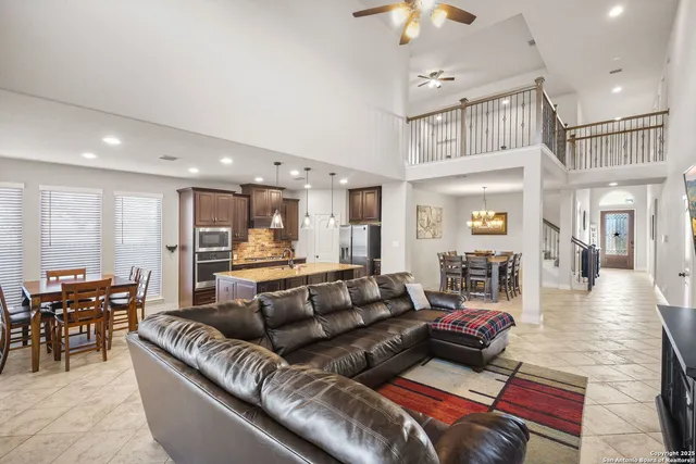 a living room with furniture kitchen view and a wooden floor