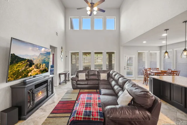 a living room with furniture a flat screen tv and a fireplace