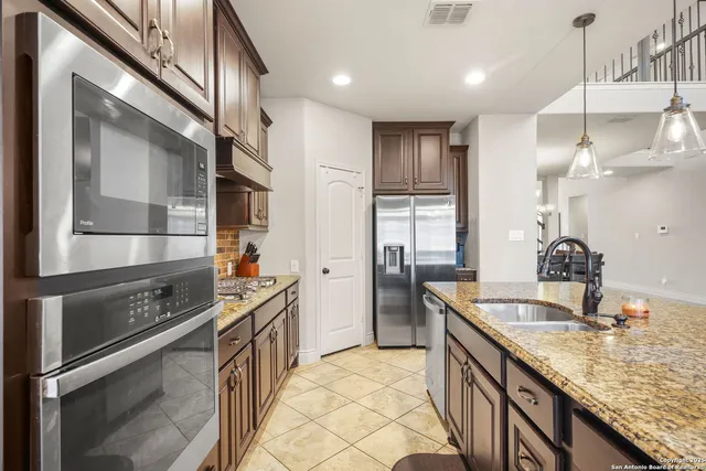 a kitchen with stainless steel appliances granite countertop a sink stove and refrigerator