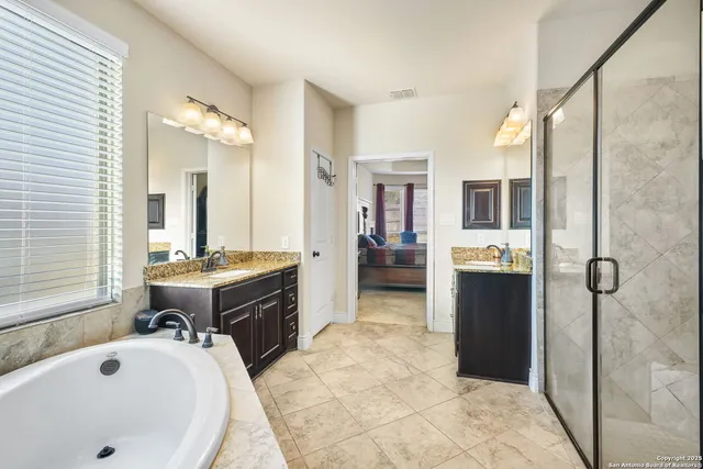 a spacious bathroom with a tub sink shower and mirror