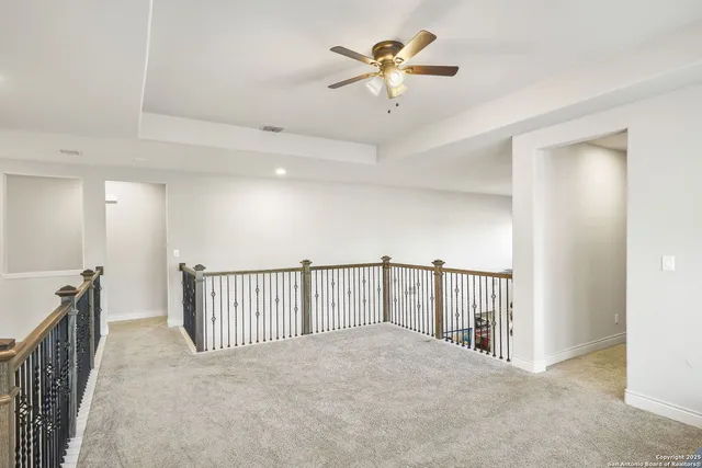 a view of staircase with a ceiling fan