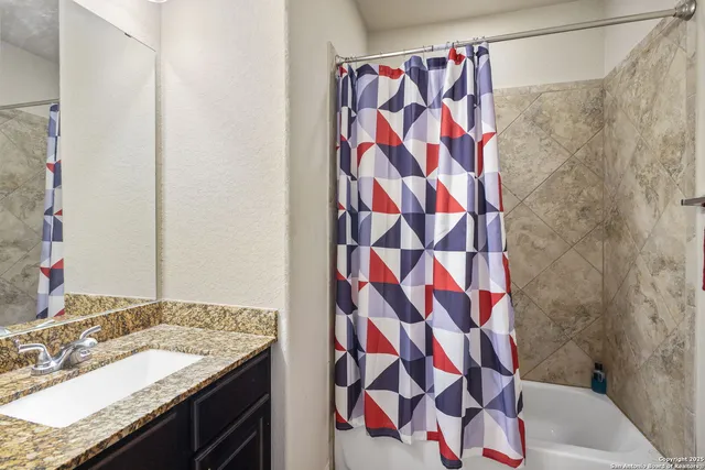 a bathroom with a granite countertop sink and a mirror