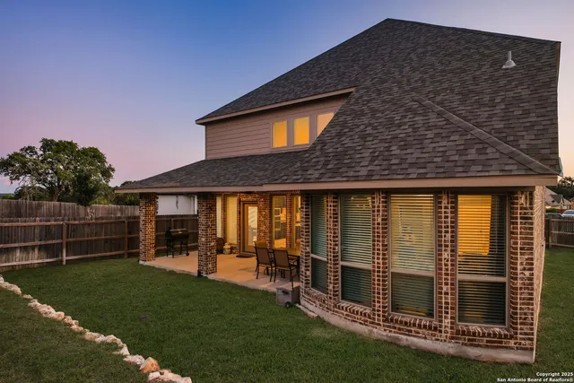 a backyard of a house with table and chairs