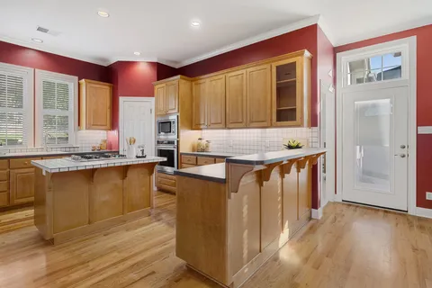 a kitchen with stainless steel appliances granite countertop a stove a sink and a refrigerator