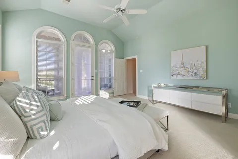 a spacious bedroom with a bed and a chandelier