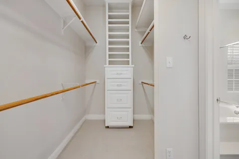 a view of walk in closet with empty racks