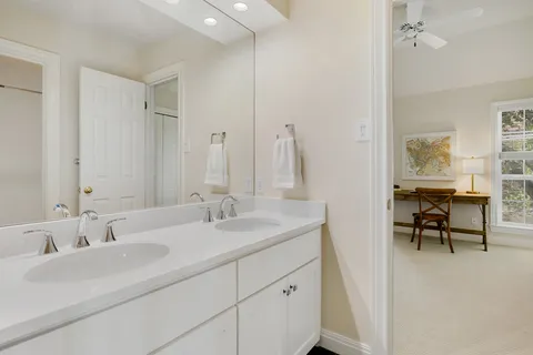 a bathroom with double vanity sink and a mirror