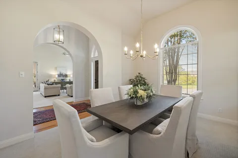 a view of a dining room with furniture and chandelier