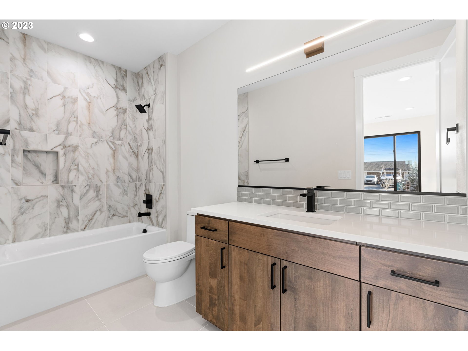 6622 Southeast Riverside Drive Vancouver, WA 98661 - Photo 42 of 46 a bathroom with a granite countertop sink a toilet a mirror a bathtub and shower