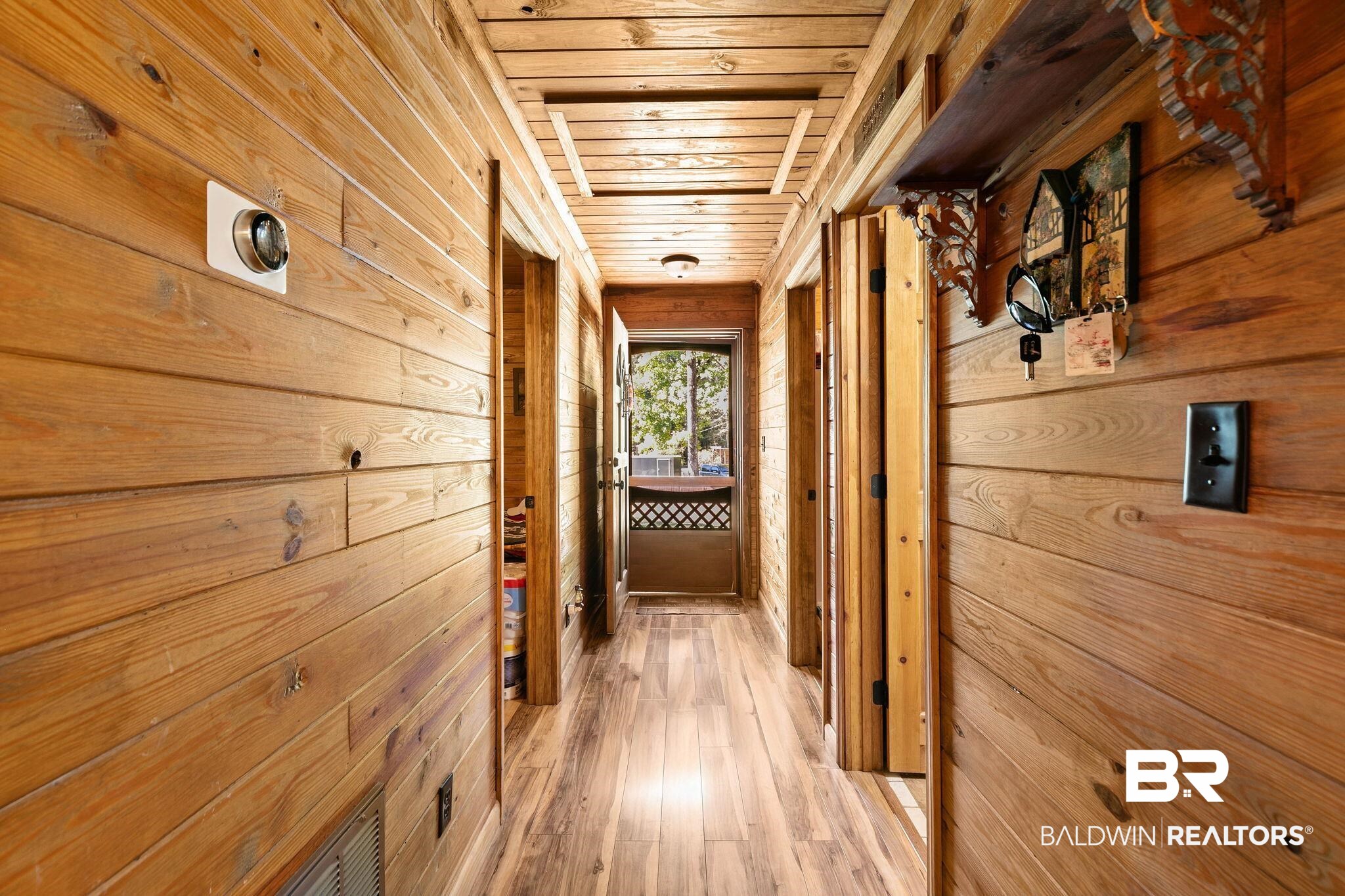 724 Rowell Lane Brewton, AL 36426 - Photo 21 of 40 Hallway featuring wood walls, wood ceiling, and light wood-style flooring