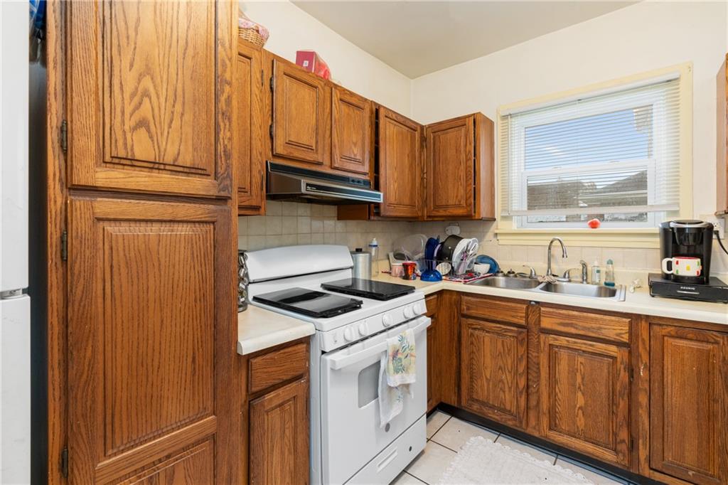 1412 4th Avenue Coraopolis, PA 15108 - Photo 6 of 14 a kitchen with stainless steel appliances granite countertop a sink stove and cabinets