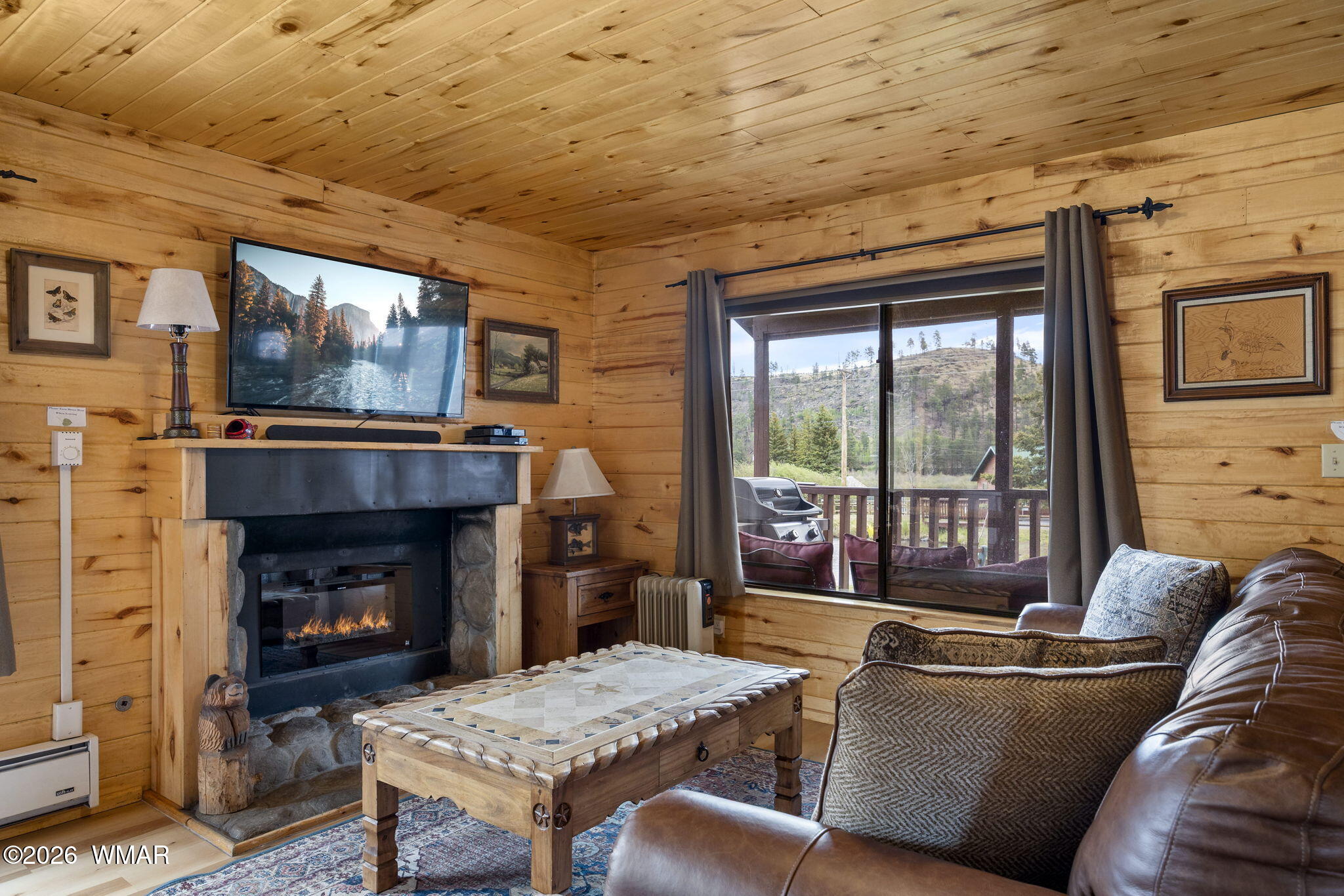 85 Main Street Greer, AZ 85927 - Photo 31 of 55 a living room with furniture a flat screen tv and a fireplace