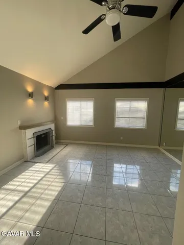 a view of an empty room with a fireplace and a window