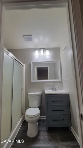 a bathroom with a toilet a sink and mirror