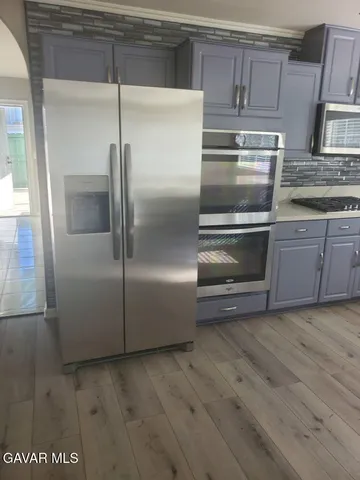 a metallic refrigerator freezer sitting in a kitchen