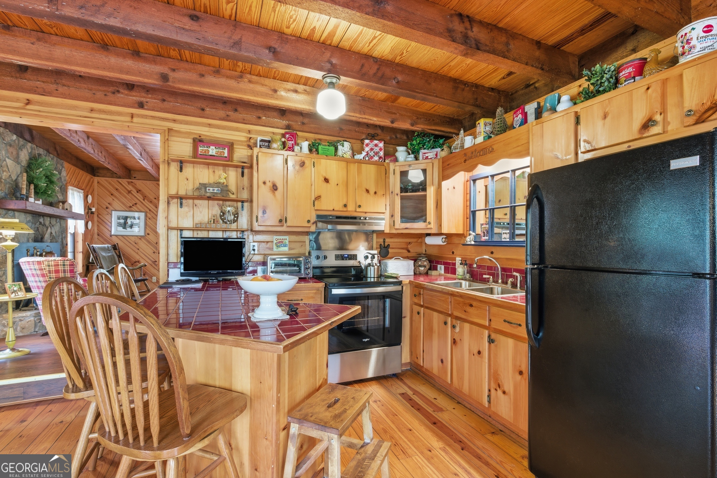 801 Sillycook Trail Clarkesville, GA 30523 - Photo 10 of 47 a kitchen with stainless steel appliances kitchen island granite countertop a table chairs and a refrigerator