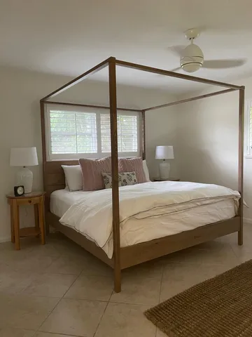 a large bed sitting in a bedroom next to a window