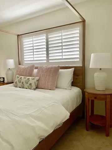 a large bed sitting in a bedroom next to a window