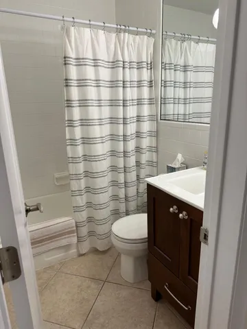 a bathroom with a sink a toilet and shower curtain