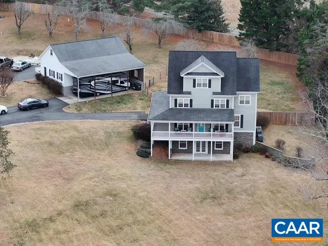 an aerial view of a house with a big yard and large trees