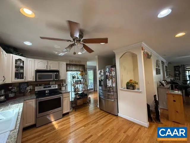 a kitchen with granite countertop a refrigerator and a stove top oven