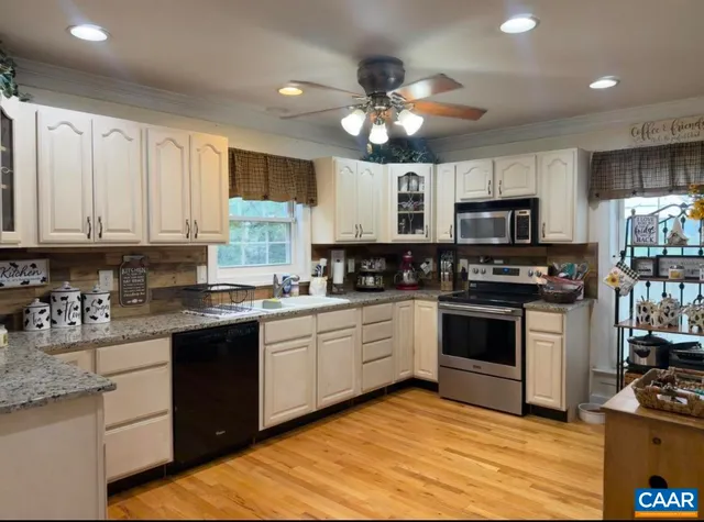 a kitchen with kitchen island granite countertop stainless steel appliances cabinets a sink and a counter top space