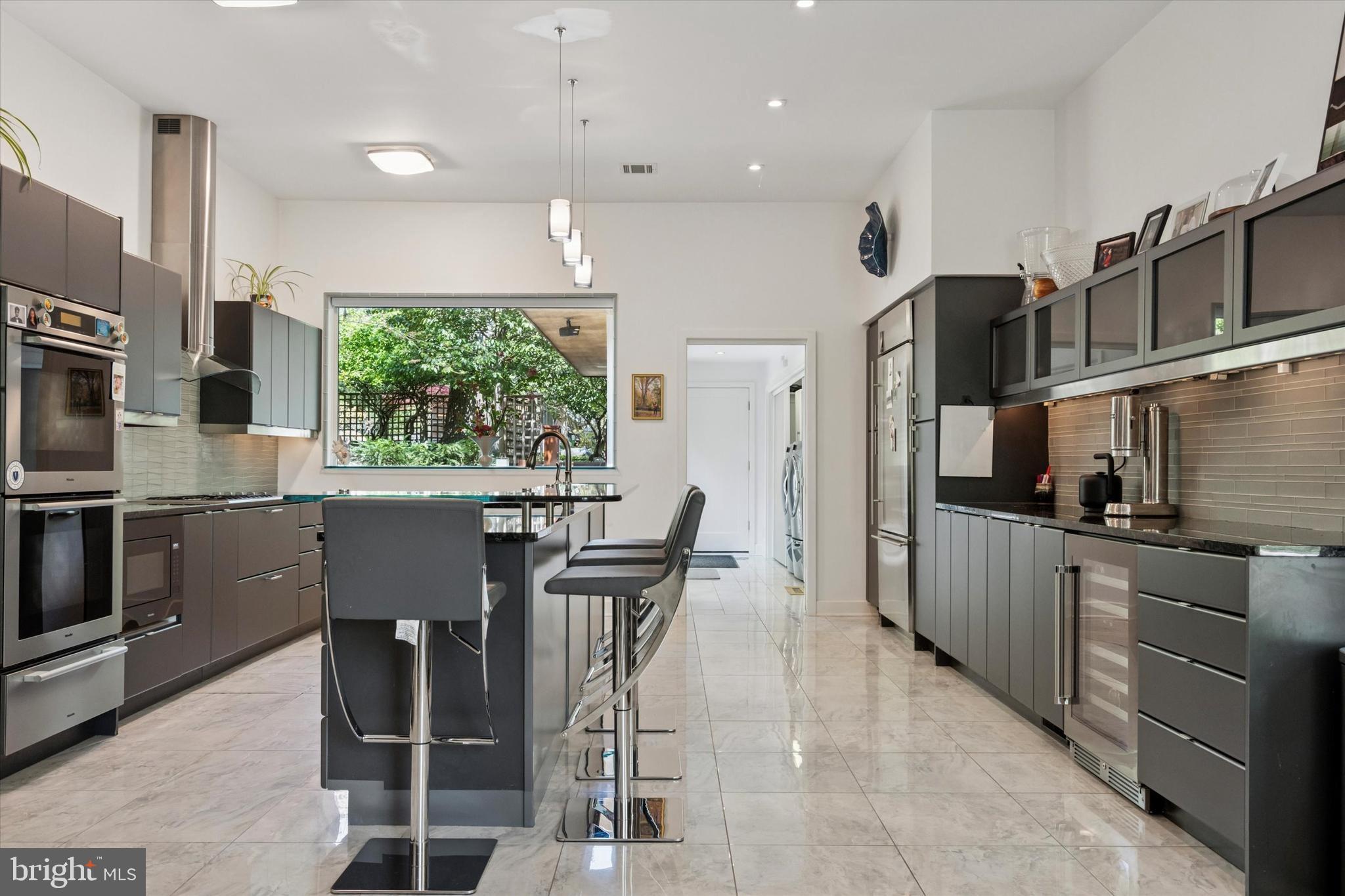 4126 Apalogen Road Philadelphia, PA 19129 - Photo 45 of 75 a kitchen with stainless steel appliances kitchen island granite countertop a table and chairs