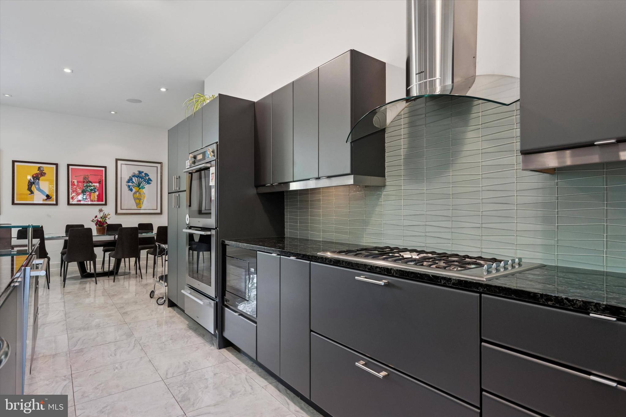 4126 Apalogen Road Philadelphia, PA 19129 - Photo 47 of 75 a kitchen with stainless steel appliances granite countertop a refrigerator and wooden cabinets