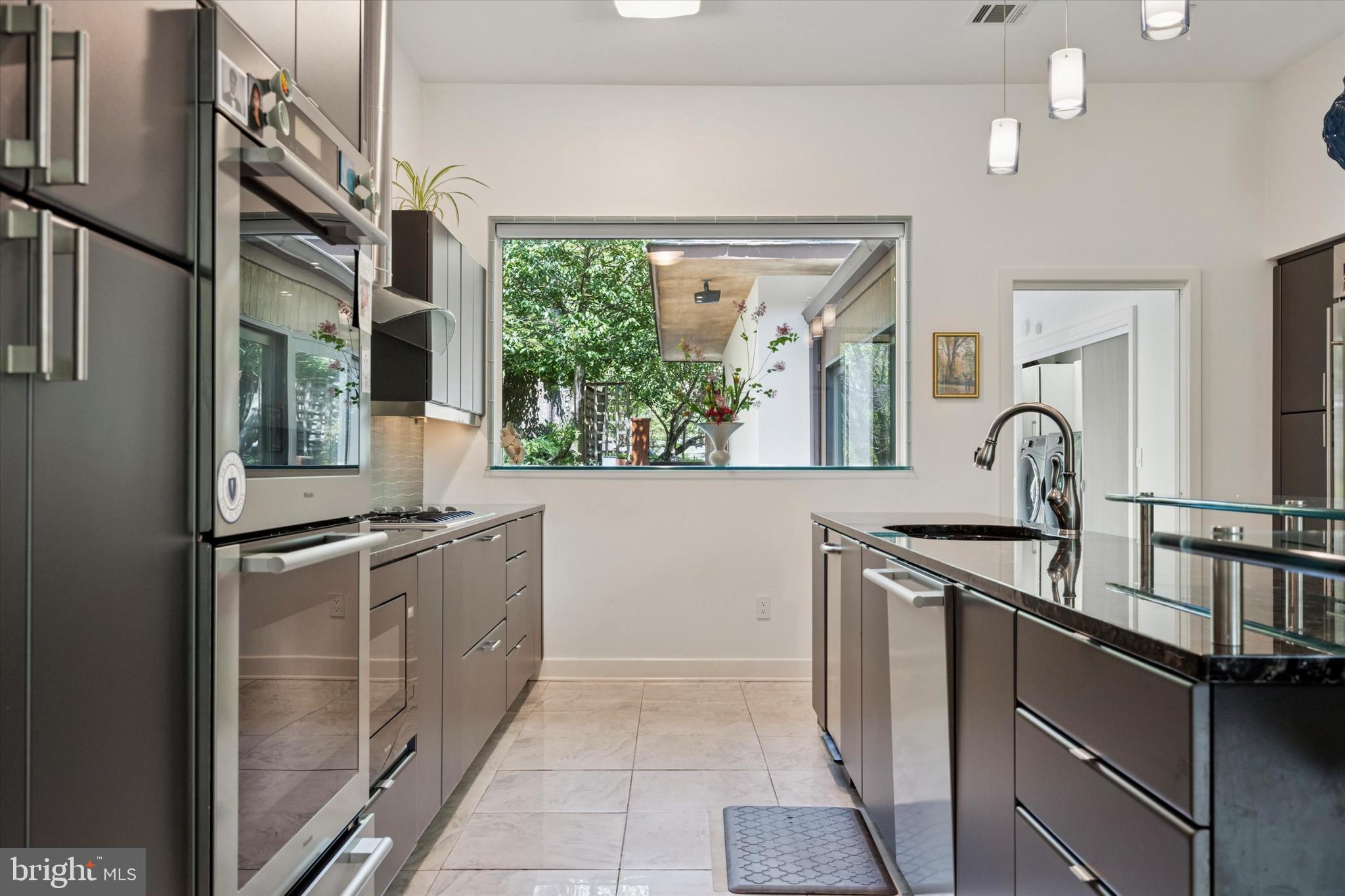 4126 Apalogen Road Philadelphia, PA 19129 - Photo 51 of 75 a kitchen with stainless steel appliances granite countertop a sink and a stove