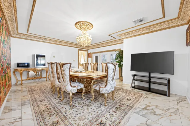 a living room with furniture a flat screen tv and a chandelier