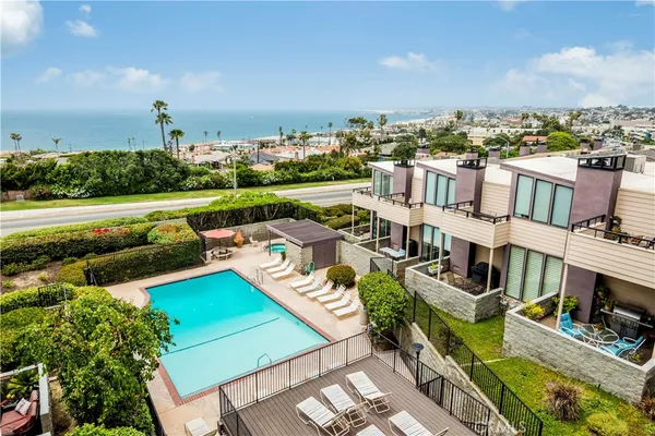 an aerial view of residential houses with outdoor space and ocean view