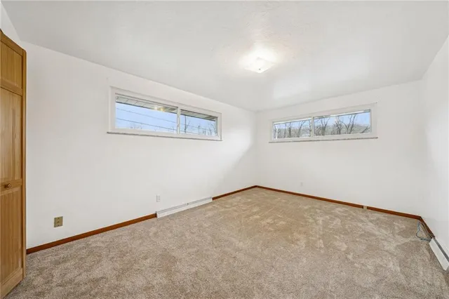 an empty room with a painting on the wall