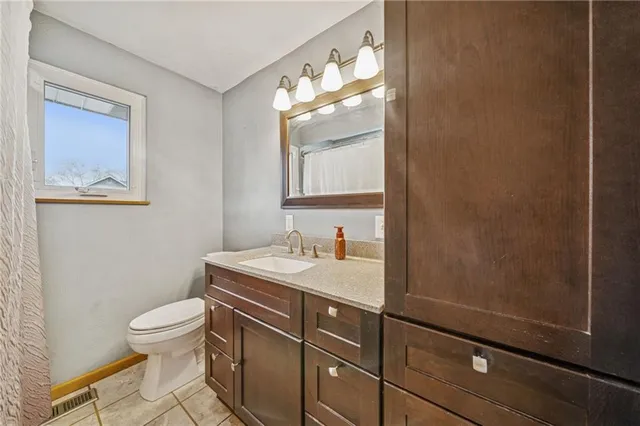 a bathroom with a toilet a sink and mirror