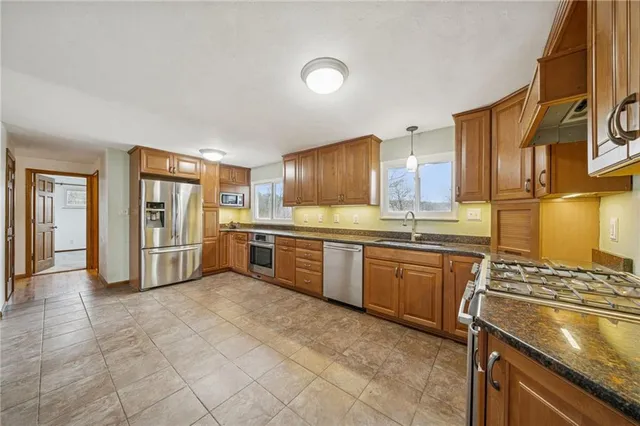 a kitchen with stainless steel appliances granite countertop a stove sink and cabinets