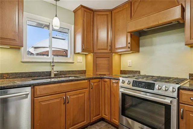 a kitchen with stainless steel appliances granite countertop a stove a sink and a microwave