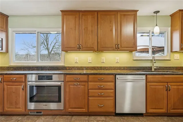 a kitchen with stainless steel appliances granite countertop a stove a sink and a microwave