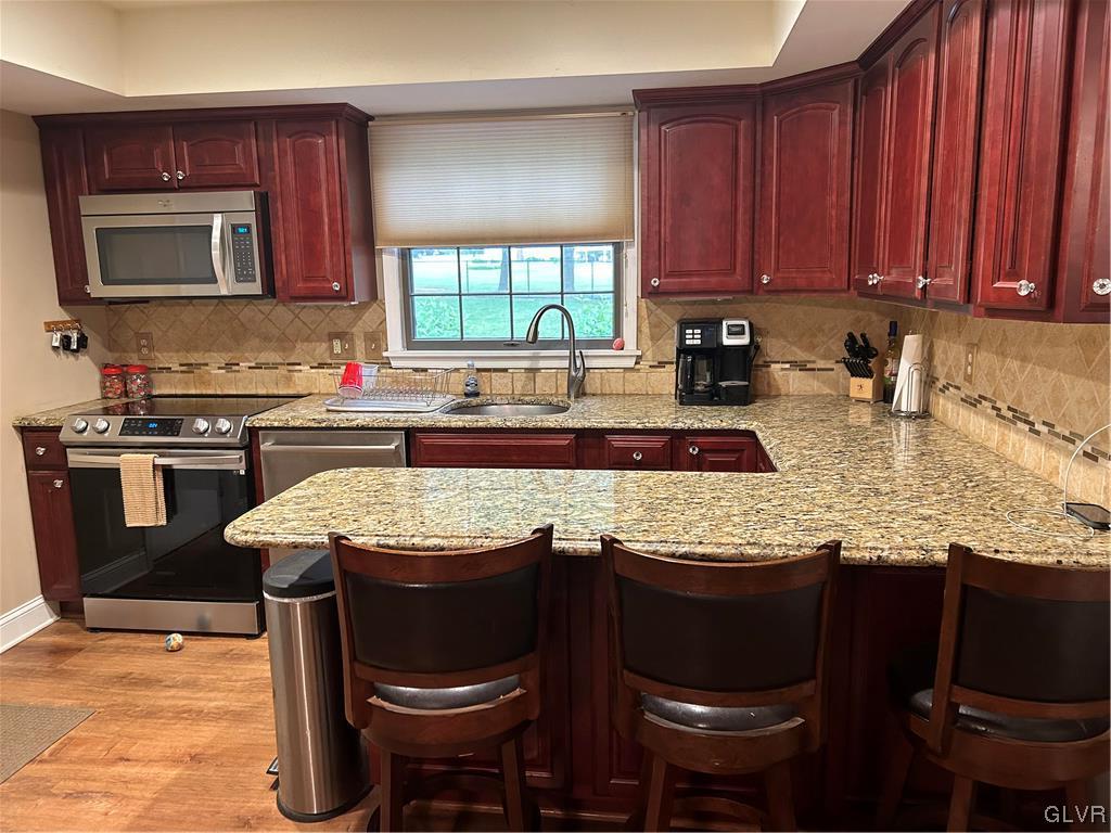 2139 Amlisa Road Nazareth, PA 18064 - Photo 18 of 35 a kitchen with granite countertop a stove a sink a microwave and wooden cabinets