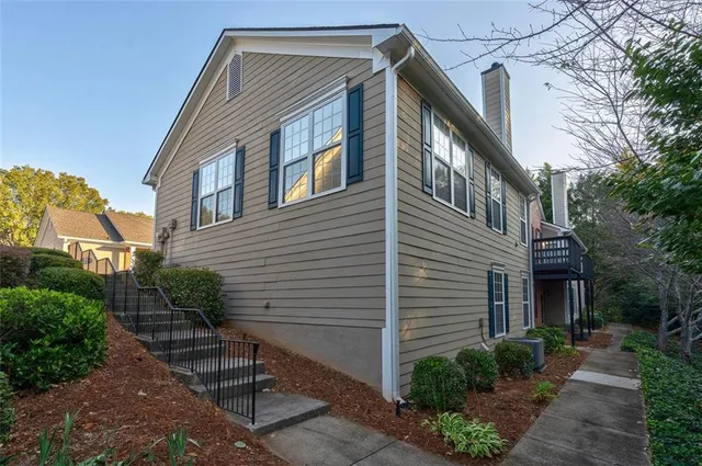 a backyard of a house with plants and outdoor seating