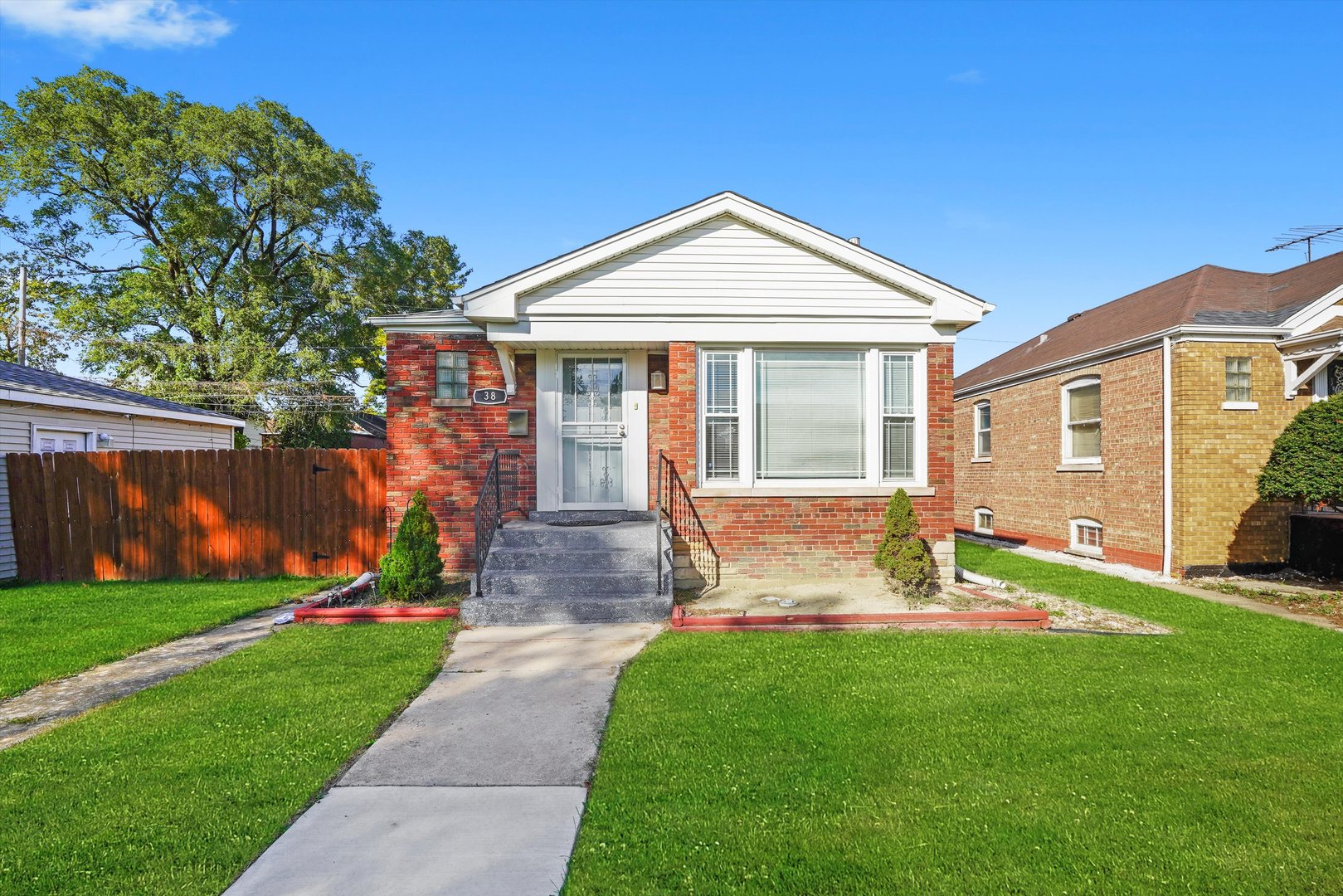 a front view of a house with a yard and trees