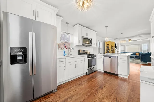a kitchen with white cabinets and stainless steel appliances
