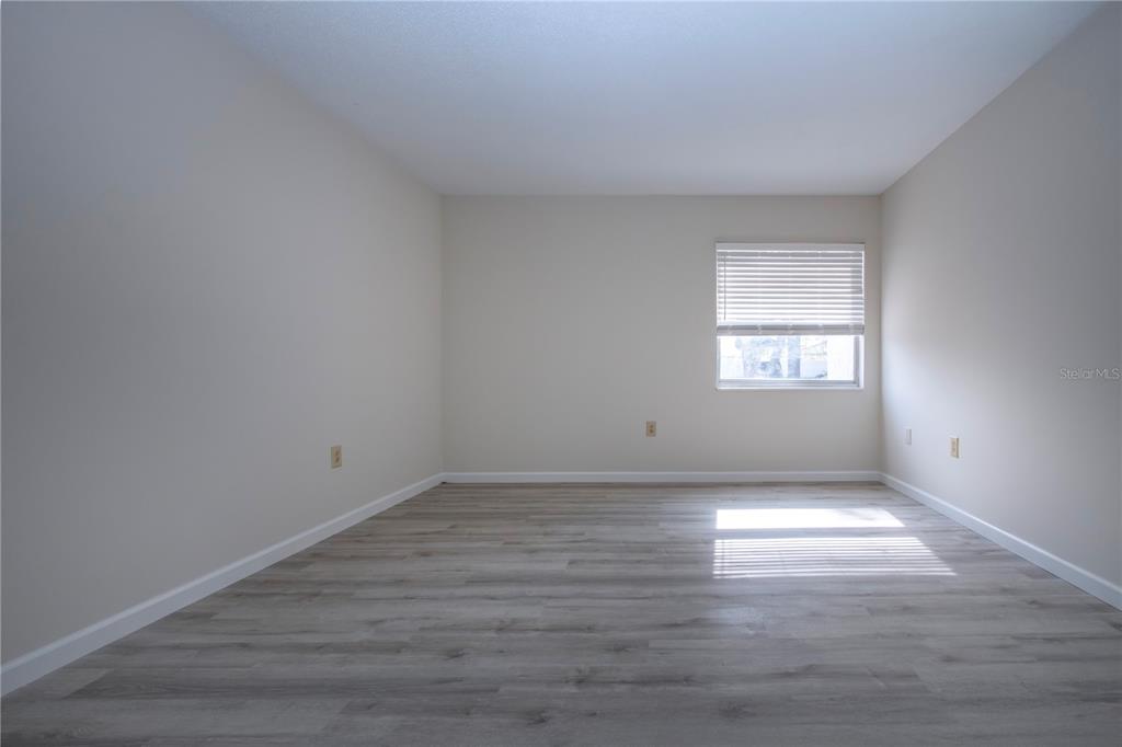 3259 South Beneva Road, Unit 102 Sarasota, FL 34232 - Photo 13 of 38 wooden floor in an empty room with a window