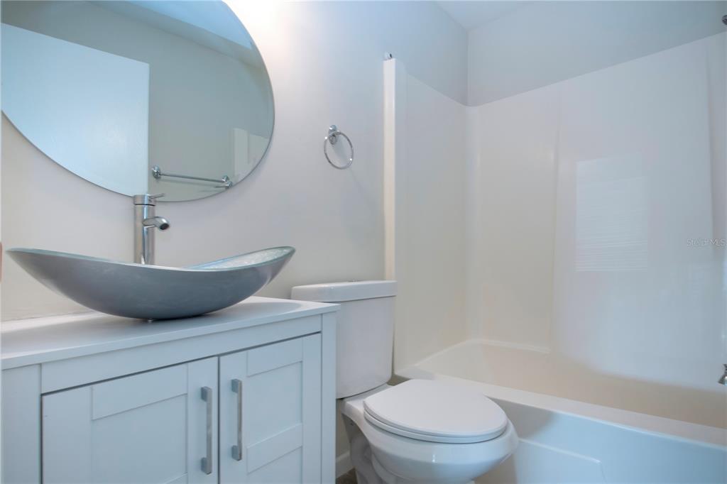 3259 South Beneva Road, Unit 102 Sarasota, FL 34232 - Photo 16 of 38 a bathroom with a granite countertop toilet a sink and bathtub