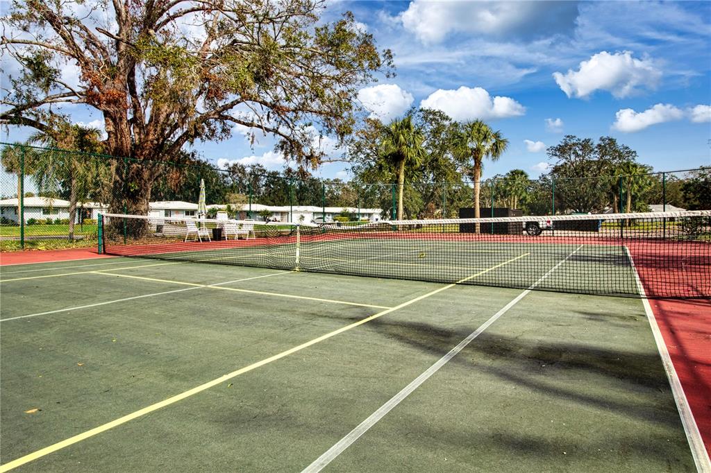 3259 South Beneva Road, Unit 102 Sarasota, FL 34232 - Photo 37 of 38 a view of tennis court with trees